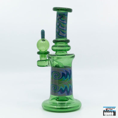 Bhomb Bhomb Worked Banger Hanger – Green Stardust & Gray Glass with Matching Bubble Cap: Stunning Green Stardust Design, Glittering Green, Gray Accents, Sophisticated Look, 4-Hole Perc Filtration, Ensures Smooth Efficient Hits, Compact and Versatile, Approximately 7.75 Inches Tall, Ideal for Tabletop or Travel, Premium Borosilicate Glass, Offers Durability, Thermal Resistance, Long-Term Use, Includes Matching Cap, Enhances Airflow Control, Better Sessions.
